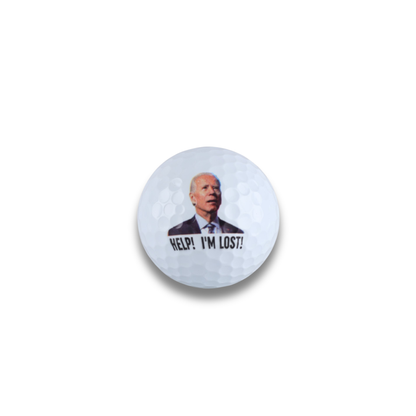 Golf ball with a printed image of a person and text 'HELP! I'M LOST?' on a light gray background